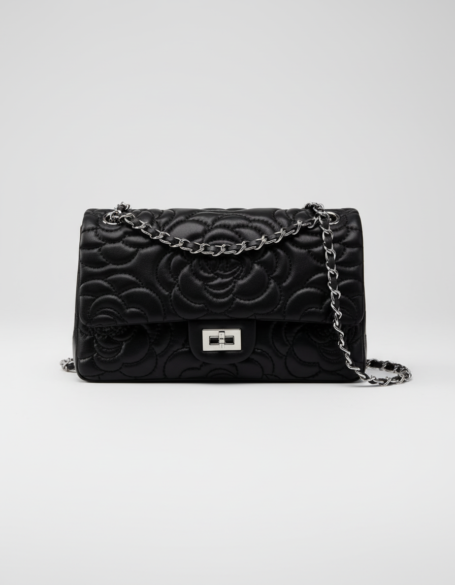 Black floral embossed handbag with a chain strap on a white background