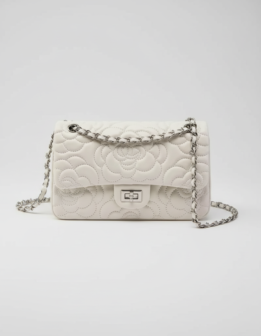 White quilted handbag with a chain strap on a white background