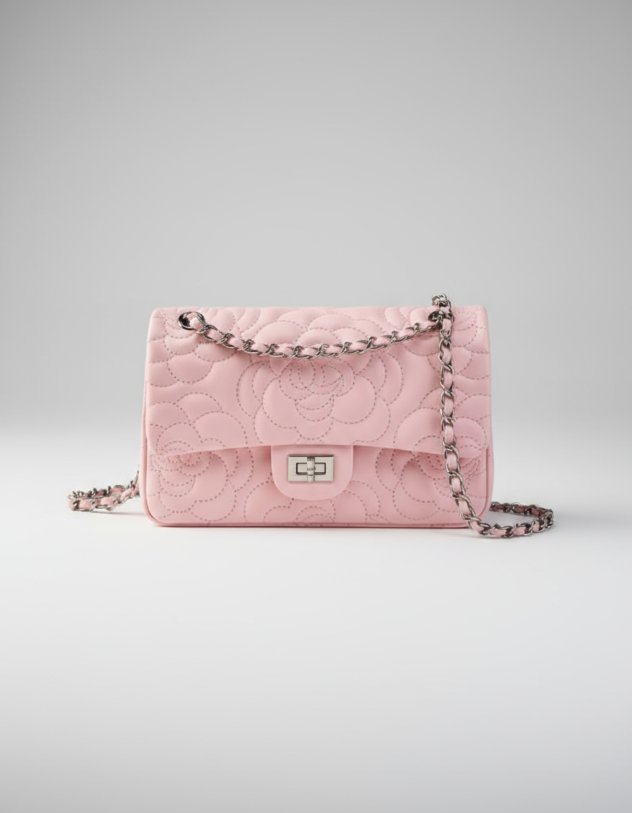 Pink quilted handbag with chain strap on a white background